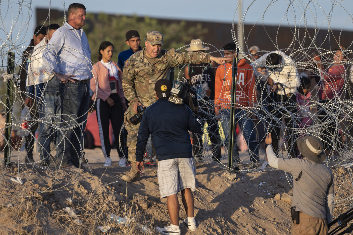 Một người lính Vệ binh Quốc gia Texas cấm các phóng viên tiếp cận những người di cư từ Mexico, ở El Paso, Texas, hôm 09/05/2023. (Ảnh: John Moore/Getty Images)