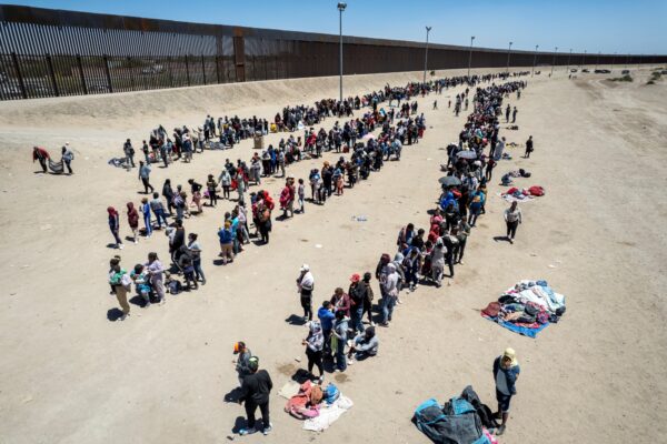 Trong một góc nhìn từ trên không, những người nhập cư bất hợp pháp xếp hàng để được làm thủ tục yêu cầu tị nạn tại một trại tạm bợ ở thành phố El Paso, tiểu bang Texas, hôm 11/05/2023. (Ảnh: John Moore/Getty Images)