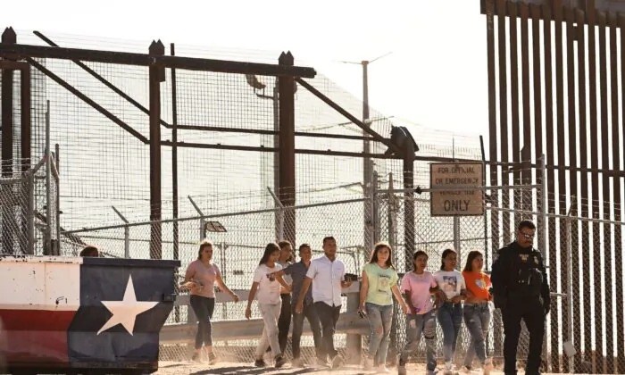 Những người nhập cư trái phép lên xe tải sau khi chờ dọc theo bức tường biên giới để đầu hàng trước các nhân viên Tuần tra Biên giới của Cục Hải quan và Biên phòng Hoa Kỳ (CBP) để được làm thủ tục nhập cư và yêu cầu tị nạn, sau khi băng qua sông Rio Grande vào Hoa Kỳ trên biên giới Hoa Kỳ-Mexico ở El Paso, Texas, hôm 11/05/2023. (Ảnh: Patrick T. Fallon/AFP qua Getty Images)