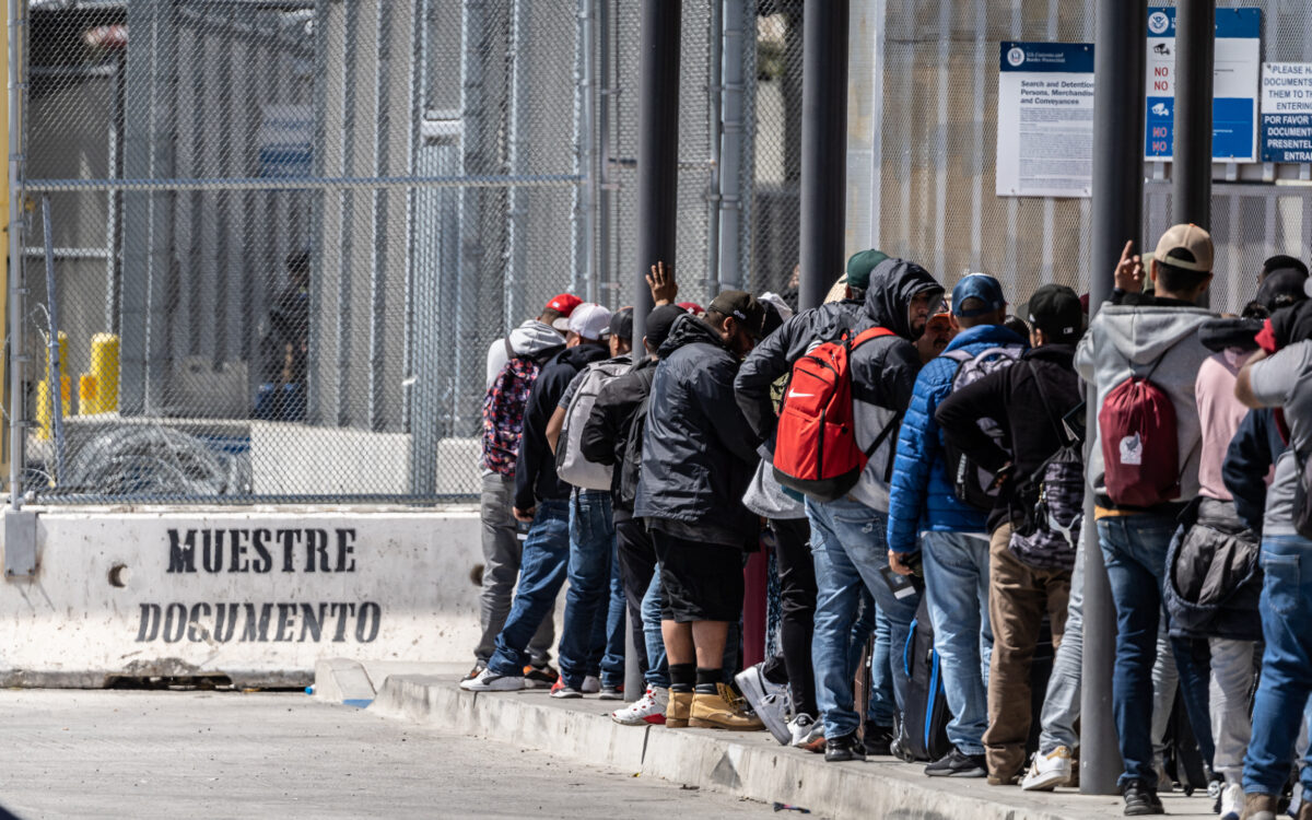 Người nhập cư xếp hàng chờ nhập cảnh vào Hoa Kỳ từ Tijuana, Mexico, hôm 11/05/2023. (Ảnh: John Fredricks/The Epoch Times)