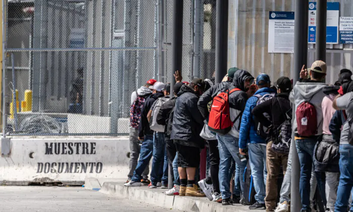 Người di cư xếp hàng chờ vào Hoa Kỳ từ Tijuana, Mexico, hôm 11/05/2023. (Ảnh: John Fredricks/The Epoch Times)