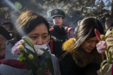 Một cảnh sát bán quân sự theo dõi những người thờ cúng Trung Quốc khi họ cầu khấn tại Ung Hòa Cung (hay còn gọi là Chùa Lạt Ma) ở Bắc Kinh, Trung Quốc, vào ngày 08/02/2016. (Ảnh: Kevin Frayer/Getty Images)