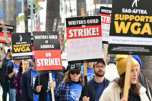 Các nhà biên kịch đình công tuần hành với các biển hiệu trên dòng người biểu tình vào ngày thứ tư của cuộc đình công của Hiệp hội Biên kịch Nhà văn Mỹ trước Netflix ở Hollywood, California, hôm 05/05/2023. (Ảnh: Frederic J. Brown/AFP qua Getty Images)