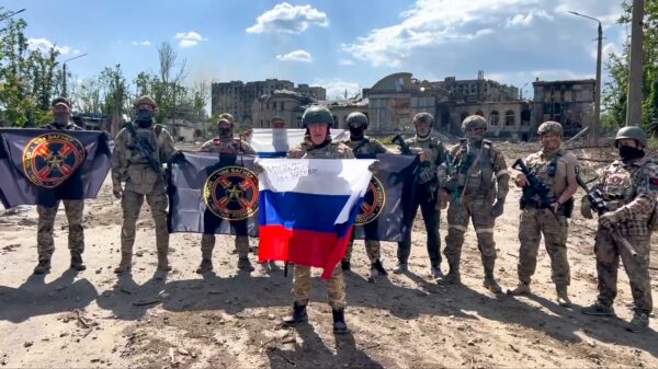 Ông Yevgeny Prigozhin, người đứng đầu công ty quân sự của Tập đoàn Wagner, cầm quốc kỳ Nga trước những người lính của mình ở Bakhmut, Ukraine, trong một cảnh tĩnh trích từ một đoạn video được công bố hôm 20/05/2023. (Ảnh: Dịch vụ báo chí của Prigozhin qua AP)
