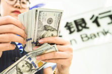 Một nhân viên ngân hàng Trung Quốc đếm các tờ tiền dollar Mỹ tại một quầy giao dịch ngân hàng ở Nam Thông, tỉnh Giang Tô, miền đông Trung Quốc hôm 06/08/2019. (Ảnh: STR/AFP/Getty Images)