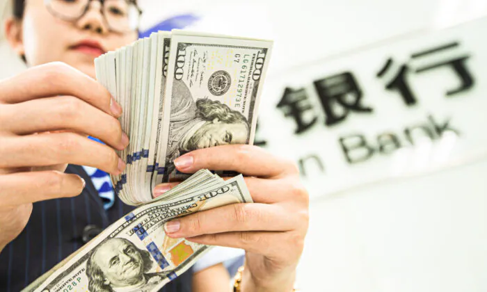 Một nhân viên ngân hàng Trung Quốc đếm các tờ tiền dollar Mỹ tại một quầy giao dịch ngân hàng ở Nam Thông, tỉnh Giang Tô, miền đông Trung Quốc hôm 06/08/2019. (Ảnh: STR/AFP/Getty Images)