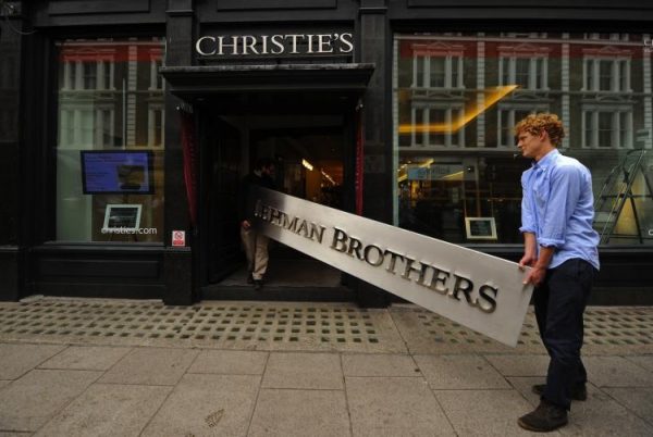 Các nhân viên mang bảng hiệu của Lehman Brothers vào nhà đấu giá Christie’s ở London. Bảng hiệu đã được bán như một phần của thương vụ ‘Anh em nhà Lehman: Tác phẩm nghệ thuật và Phù du’. (Ảnh: Ben Stansall/AFP/Getty Images)