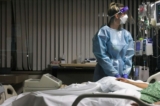 Một y tá đang kiểm tra màn hình trong một phòng bệnh. (Mario Tama/Getty Images)