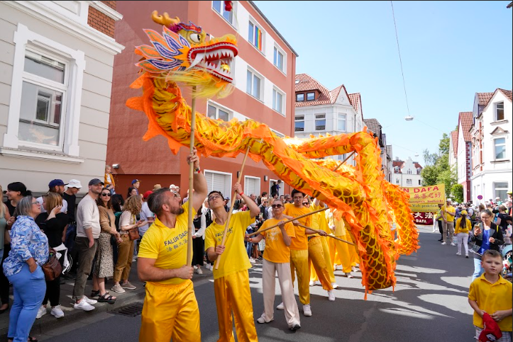 Công chúng chào đón đoàn diễn hành của các học viên Pháp Luân Công tại lễ hội văn hóa Carnival ở Bielefeld, Đức