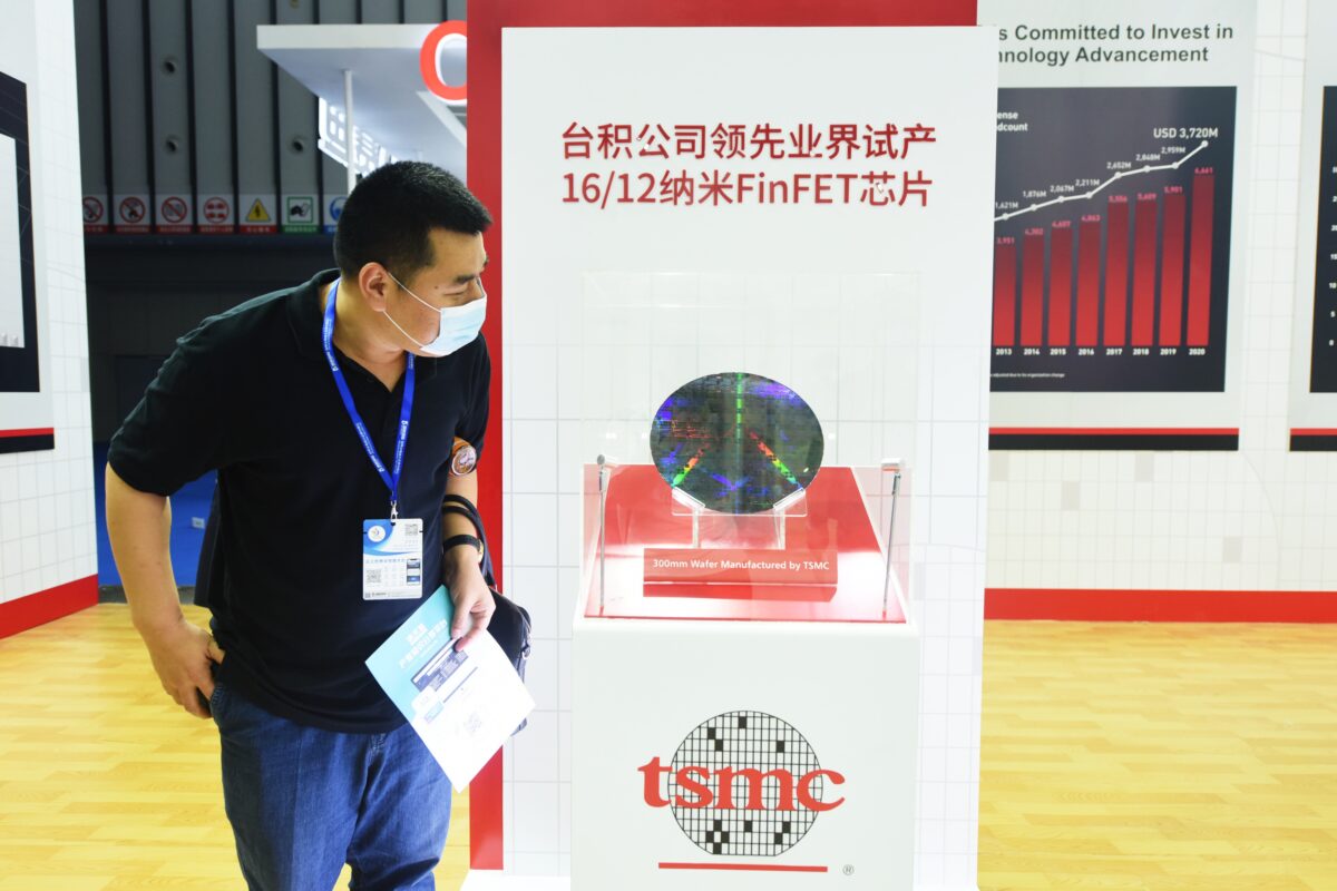 Một khách thăm quan xem tấm wafer 300mm tại gian hàng của Công ty TNHH Sản xuất Chất bán dẫn Đài Loan (TSMC) trong Hội nghị Chất bán dẫn Thế giới năm 2021 ở thành phố Nam Kinh, tỉnh Giang Tô, Trung Quốc, vào ngày 09/06/2021. (Ảnh Long Wei/VCG qua Getty Images)