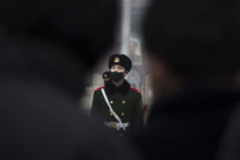 Một viên cảnh sát bán quân sự Trung Quốc đeo khẩu trang tránh bụi tuần hành trong màn sương mờ tại Quảng trường Thiên An Môn ở Bắc Kinh vào ngày 09/12/2015. (Ảnh: Kevin Frayer/Getty Images)