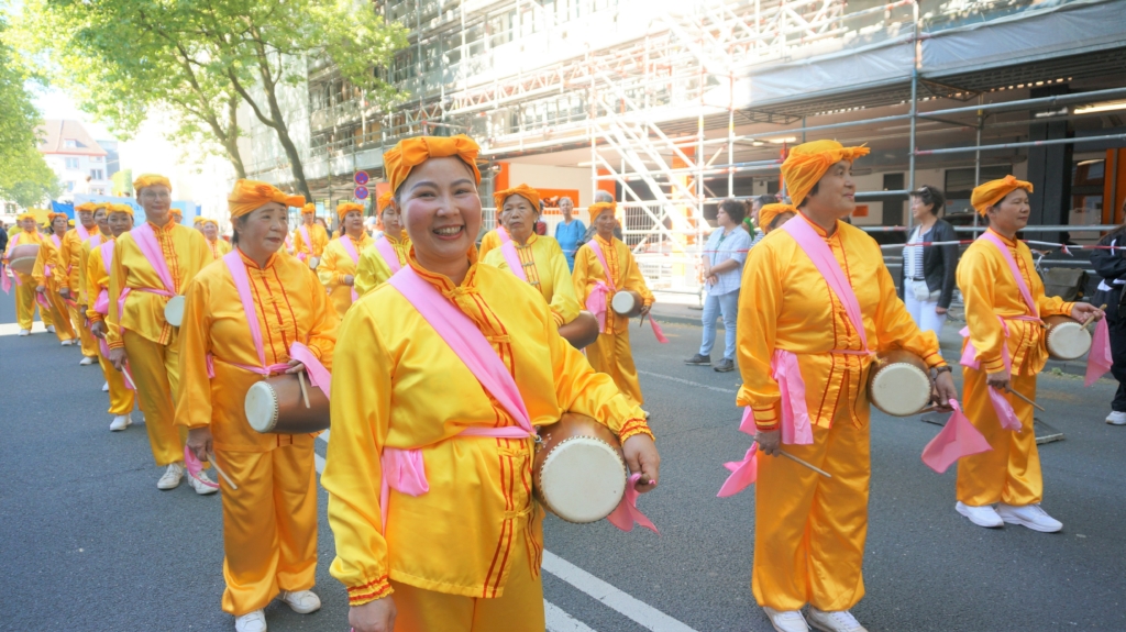 Công chúng chào đón đoàn diễn hành của các học viên Pháp Luân Công tại lễ hội văn hóa Carnival ở Bielefeld, Đức