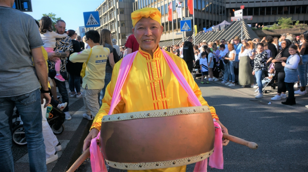 Công chúng chào đón đoàn diễn hành của các học viên Pháp Luân Công tại lễ hội văn hóa Carnival ở Bielefeld, Đức