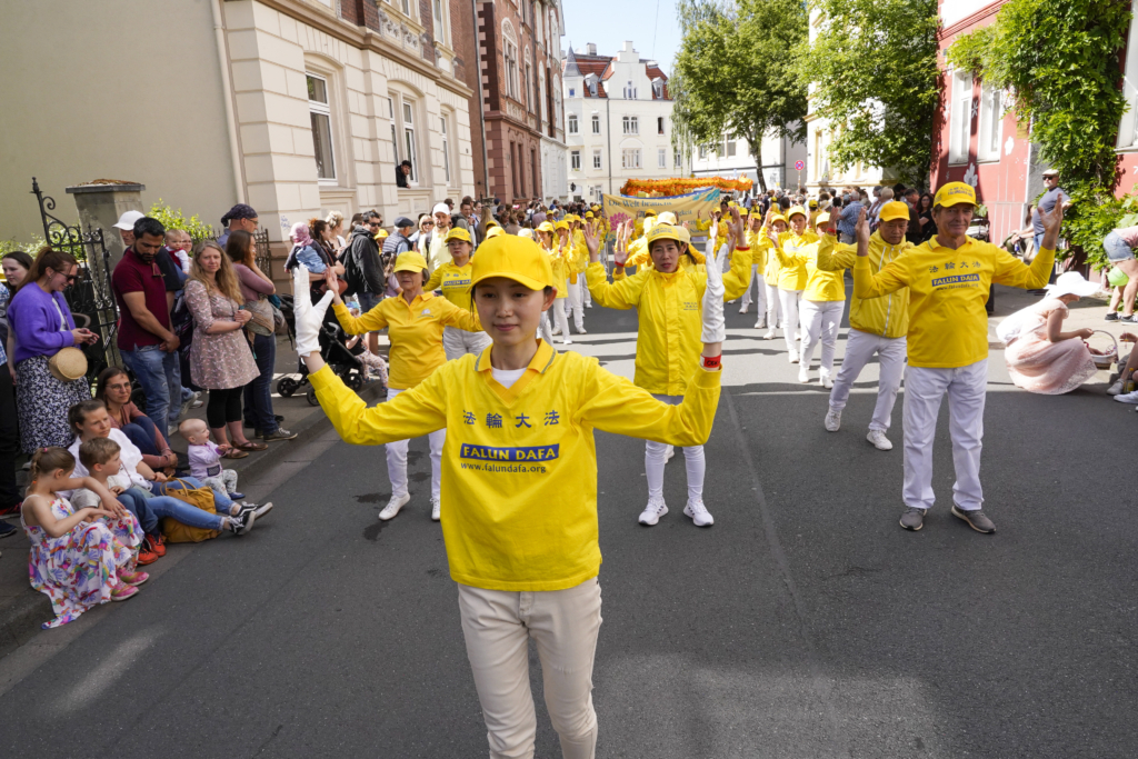 Công chúng chào đón đoàn diễn hành của các học viên Pháp Luân Công tại lễ hội văn hóa Carnival ở Bielefeld, Đức