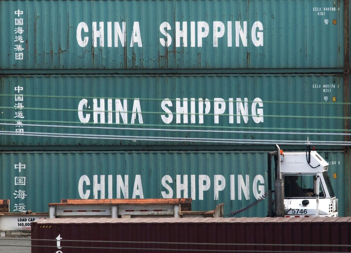 Một chiếc xe tải đi ngang qua các container của China Shipping tại Cảng Los Angeles ở Long Beach, California, hôm 01/09/2019. (Ảnh: Mark Ralston/AFP qua Getty Images)