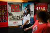 Mọi người đi ngang qua một tấm bích chương bộ phim ‘1921’, một bộ phim tuyên truyền về việc thành lập ĐCSTQ, tại Bắc Kinh, vào ngày 28/06/2021. (Ảnh: Wang Zhao/AFP qua Getty Images)