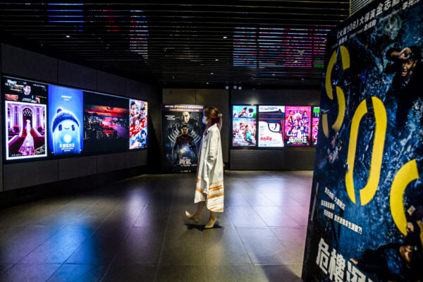 Một phụ nữ xem quảng cáo phim tại một rạp chiếu phim ở Hồng Kông vào ngày 02/09/2021. (Ảnh: Isaac Lawrence/AFP qua Getty Images)