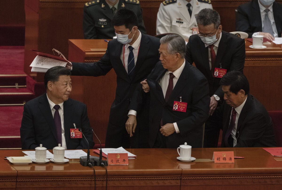 Chủ tịch Trung Quốc Tập Cận Bình (Trái) nhìn cựu Chủ tịch Hồ Cẩm Đào được dìu ra khỏi phiên bế mạc của Đại hội Đại biểu Nhân dân Toàn quốc lần thứ 20 của Đảng Cộng sản Trung Quốc, tại Đại lễ đường Nhân dân ở Bắc Kinh, vào ngày 22/10/2022. (Ảnh: Kevin Frayer/Getty Images)