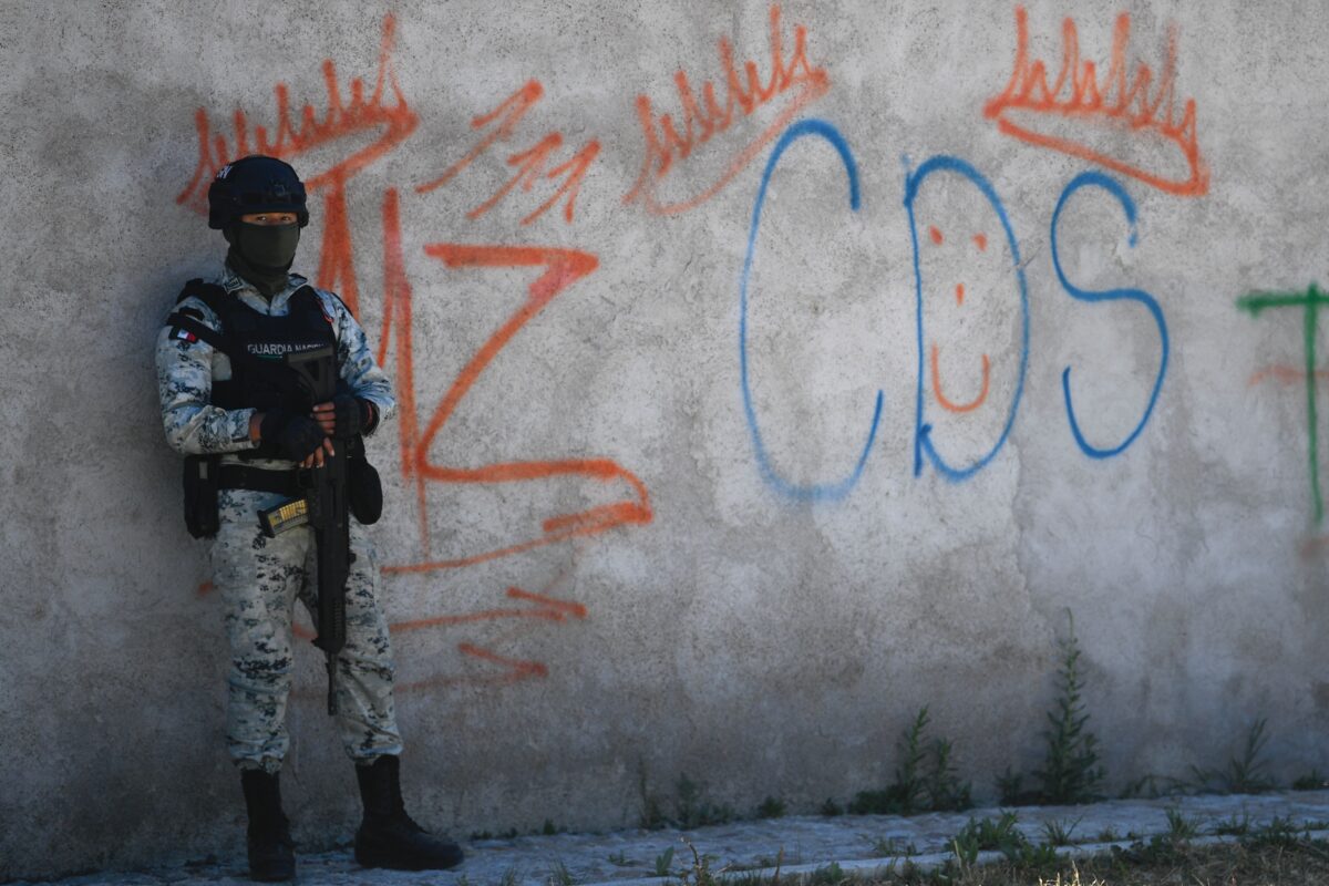 Một người lính Mexico đứng gác trước một bức tường vẽ graffiti có liên quan đến nhóm tội phạm “Cartel de Sinaloa” (CDS), ở Palmas Altas, bang Zacatecas, Mexico, hôm 14/03/2022. (Ảnh: Pedro Pardo/AFP/Getty Images)