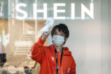 Một người đàn ông đang lau cửa sổ của phòng trưng bày cố định đầu tiên của đại công ty thời trang giá rẻ trực tuyến Trung Quốc Shein, trong buổi xem trước dành cho truyền thông ở Tokyo vào ngày 10/11/2022. (Ảnh: Richard A. Brooks/AFP qua Getty Images)