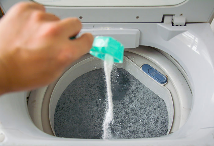 Thêm Baking soda vào nước ấm với bột giặt, sau đó mới cho quần áo bẩn vào. (Ảnh: Shutterstock)