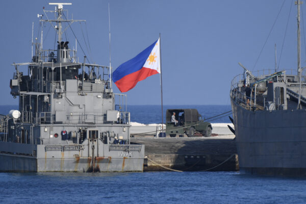 Một lá cờ Philippines tung bay bên cạnh các tàu hải quân neo đậu tại đảo Thị Tứ do Philippines chiếm đóng ở Biển Đông đang tranh chấp, hôm 21/04/2023. (Ảnh: Ted Aljibe/AFP qua Getty Images)