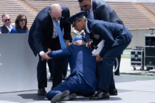 Tổng thống Joe Biden được đỡ dậy sau khi bị ngã trong lễ tốt nghiệp tại Học viện Không quân Hoa Kỳ, ngay phía bắc Colorado Springs ở Quận El Paso, Colorado, hôm 01/06/2023. (Ảnh: Brendan Smialowski/AFP qua Getty Images)