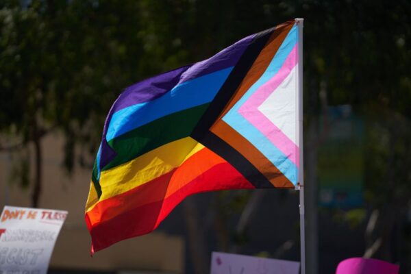 Một lá cờ Progress Pride được giương cao phía trên đám đông các nhà hoạt động LGBT trong một cuộc tập hợp ở West Hollywood, California, hôm 09/04/2023. (Ảnh: Allison Dinner/AFP qua Getty Images)