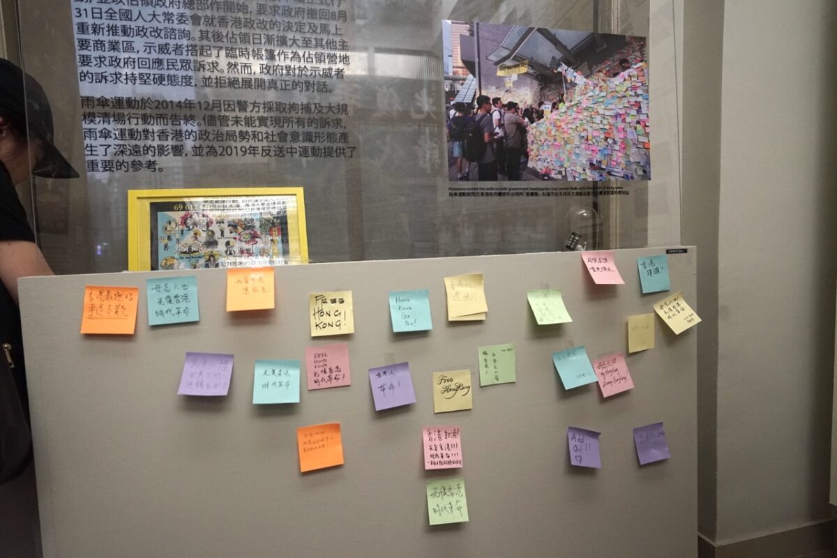 Những bức ảnh cho thấy “Những cuộc Tranh đấu mà Người dân Hồng Kông đã Bước qua — từ Sự kiện Lục tứ năm 1989 đến Phong trào Chống Dẫn độ” trên một bức tường đặc biệt của Lennon tại cuộc triển lãm hôm 03/06/2023. (Ảnh: Jenny Zeng/The Epoch Times)
