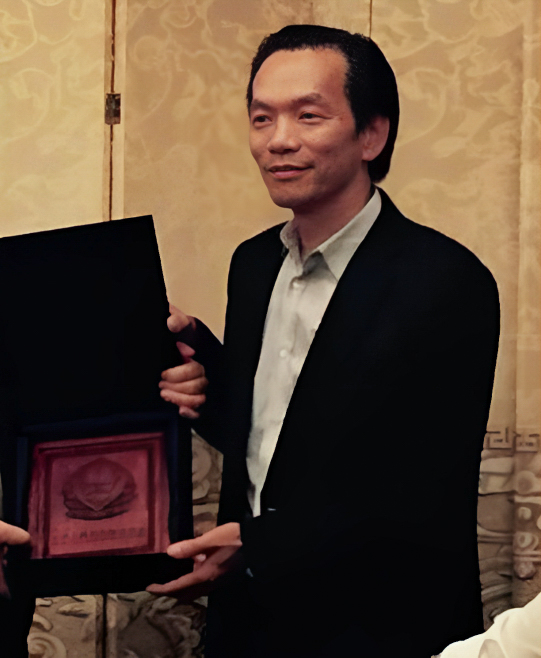 Ông Trần Kim Bình nhận bằng khen từ một quan chức của Bộ Công an Trung Quốc trong một buổi lễ sau chuyến thăm Hoa Kỳ năm 2015 của nhà lãnh đạo Trung Quốc Tập Cận Bình. (Ảnh: Bộ Tư pháp)