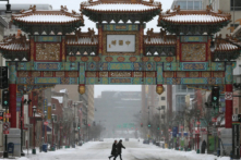 Mọi người đi bộ dưới trời tuyết gần cổng khu phố Tàu, hay còn gọi là cổng Trung Hoa (China Gate), ở thủ đô Hoa Thịnh Đốn, vào ngày 03/03/2014. (Ảnh: Mark Wilson/Getty Images)