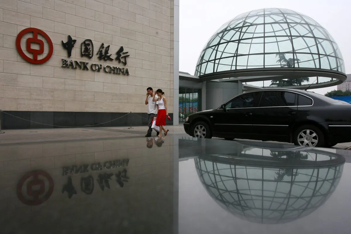 Hai người đi ngang qua trụ sở của Ngân hàng Trung Quốc, ngân hàng cho vay lớn thứ hai của quốc gia này ở Bắc Kinh, Trung Quốc, vào ngày 28/06/2006. (Ảnh: China Photos/Getty Images)