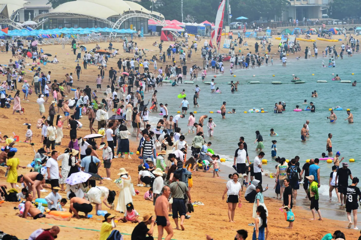 Mọi người giải nhiệt trên bãi biển giữa thời tiết nắng nóng ở Thanh Đảo, tỉnh Sơn Đông, Trung Quốc, hôm 24/06/2023. (Ảnh: STR/AFP qua Getty Images)