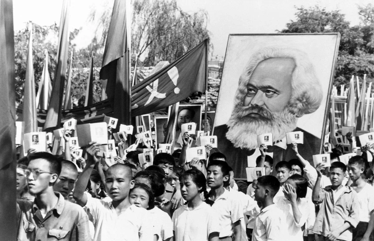 Thanh thiếu niên tại một cuộc biểu tình trong thời kỳ cao điểm của cuộc biến động Hồng Vệ binh đang vẫy các bản sao của Cuốn sách Tiểu Hồng Mao và mang theo một tấm bích chương ảnh Karl Marx vào ngày 14/09/1966. Cách mạng Văn hóa đã mở ra một thập niên bạo lực và hỗn loạn để đạt được các mục tiêu cộng sản và thực thi chính sách chủ nghĩa bình quân cực đoan. (Ảnh: AP Photo)