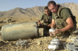 Những người lính Pháp thuộc Lực lượng Hỗ trợ An ninh Quốc tế (ISAF) dỡ bom chùm do Nga sản xuất từ một thùng chứa được tìm thấy khoảng 18 dặm về phía bắc của Kabul, Afghanistan, vào ngày 09/10/2002. (Ảnh: Lynne Sladky/AP Photo)