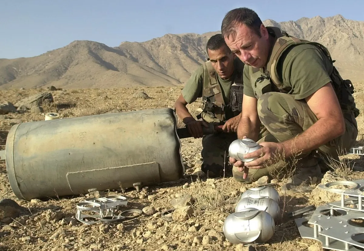 Những người lính Pháp thuộc Lực lượng Hỗ trợ An ninh Quốc tế (ISAF) dỡ bom chùm do Nga sản xuất từ một thùng chứa được tìm thấy khoảng 18 dặm về phía bắc của Kabul, Afghanistan, vào ngày 09/10/2002. (Ảnh: Lynne Sladky/AP Photo)