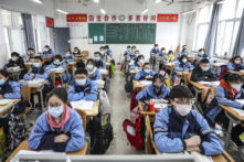 Học sinh năm ba của trường cấp hai và cấp ba trở lại lớp học sau khi kỳ khai giảng bị hoãn do dịch bệnh virus Trung Cộng bùng phát ở Hoài An, tỉnh Giang Tô, Trung Quốc, vào ngày 30/03/2020. (Ảnh: STR/AFP qua Getty Images)