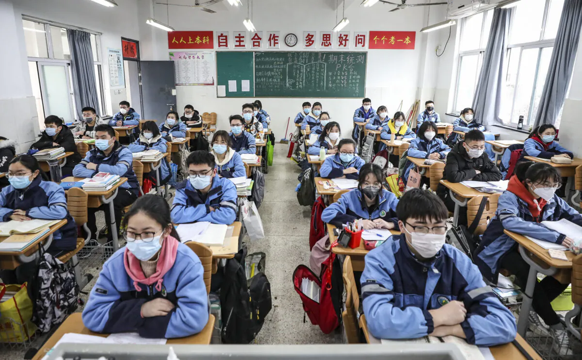 Học sinh năm ba của trường cấp hai và cấp ba trở lại lớp học sau khi kỳ khai giảng bị hoãn do dịch bệnh virus Trung Cộng bùng phát ở Hoài An, tỉnh Giang Tô, Trung Quốc, vào ngày 30/03/2020. (Ảnh: STR/AFP qua Getty Images)