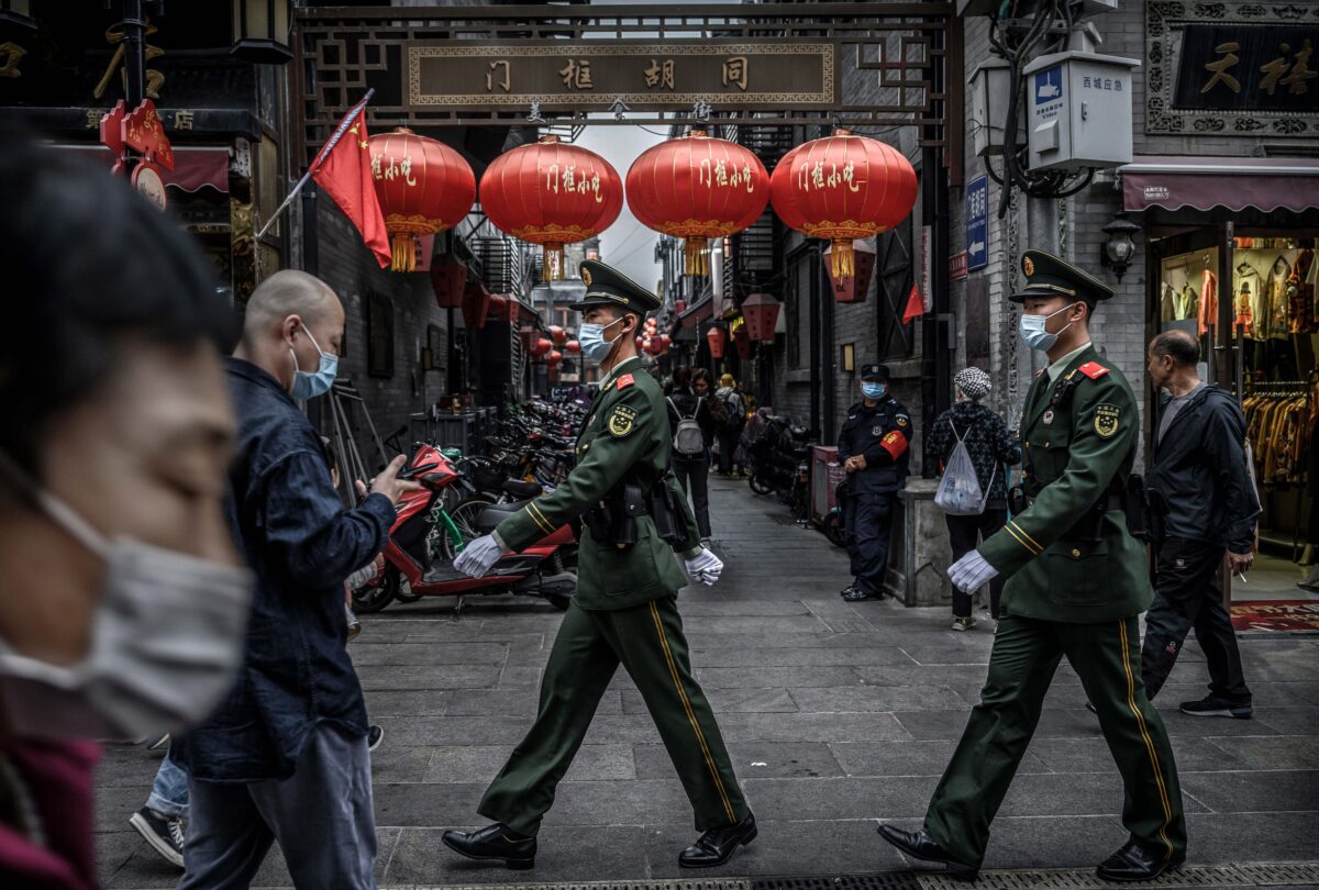 Công an Trung Quốc tuần tra trong lúc du khách đi dạo trong một khu mua sắm sầm uất trong ngày cuối cùng của kỳ nghỉ Tuần lễ Vàng ở Bắc Kinh, Trung Quốc vào ngày 08/10/2020. (Ảnh: Kevin Frayer/Getty Images)