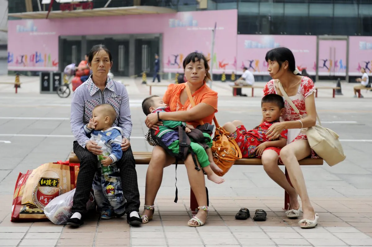 Những người phụ nữ ngồi với con của họ trên băng ghế tại một con phố ở Bắc Kinh ngày 06/09/2012. (Ảnh: Wang Zhao/AFP/Getty Images)