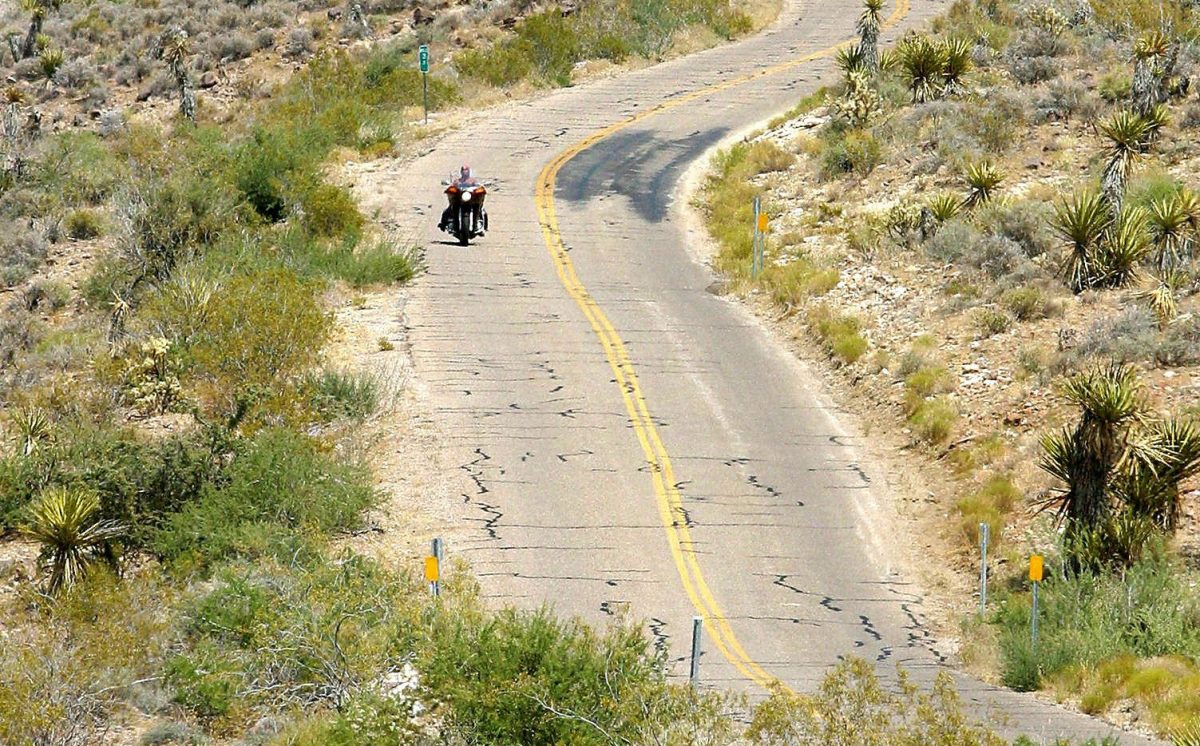 Một người lái mô tô độc hành đi trên con đường lịch sử Route 66 ngang qua phía tây sa mạc Arizona trên đường đến Oatman, Arizona, vào ngày 12/06/2003. (Robyn Beck/AFP/Getty Images)