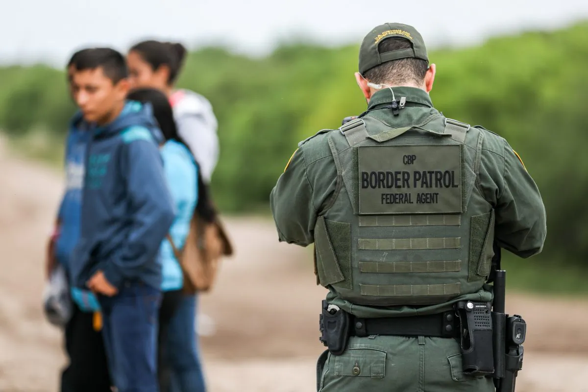Một nhân viên Bảo vệ Biên giới Hoa Kỳ bắt giữ những người nhập cư bất hợp pháp vừa vượt sông Rio Grande từ Mexico để vào thành phố Penitas, Texas, vào ngày 21/03/2019. (Ảnh: Charlotte Cuthbertson/The Epoch Times)