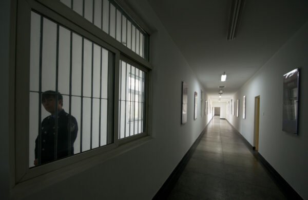 Một lính canh nhìn qua cửa sổ của một hành lang bên trong Trung tâm Giam giữ Số 1 trong một chuyến tham quan do chính quyền chỉ thị ở Bắc Kinh vào ngày 25/10/2012. (Ed Jones/AFP qua Getty Images)