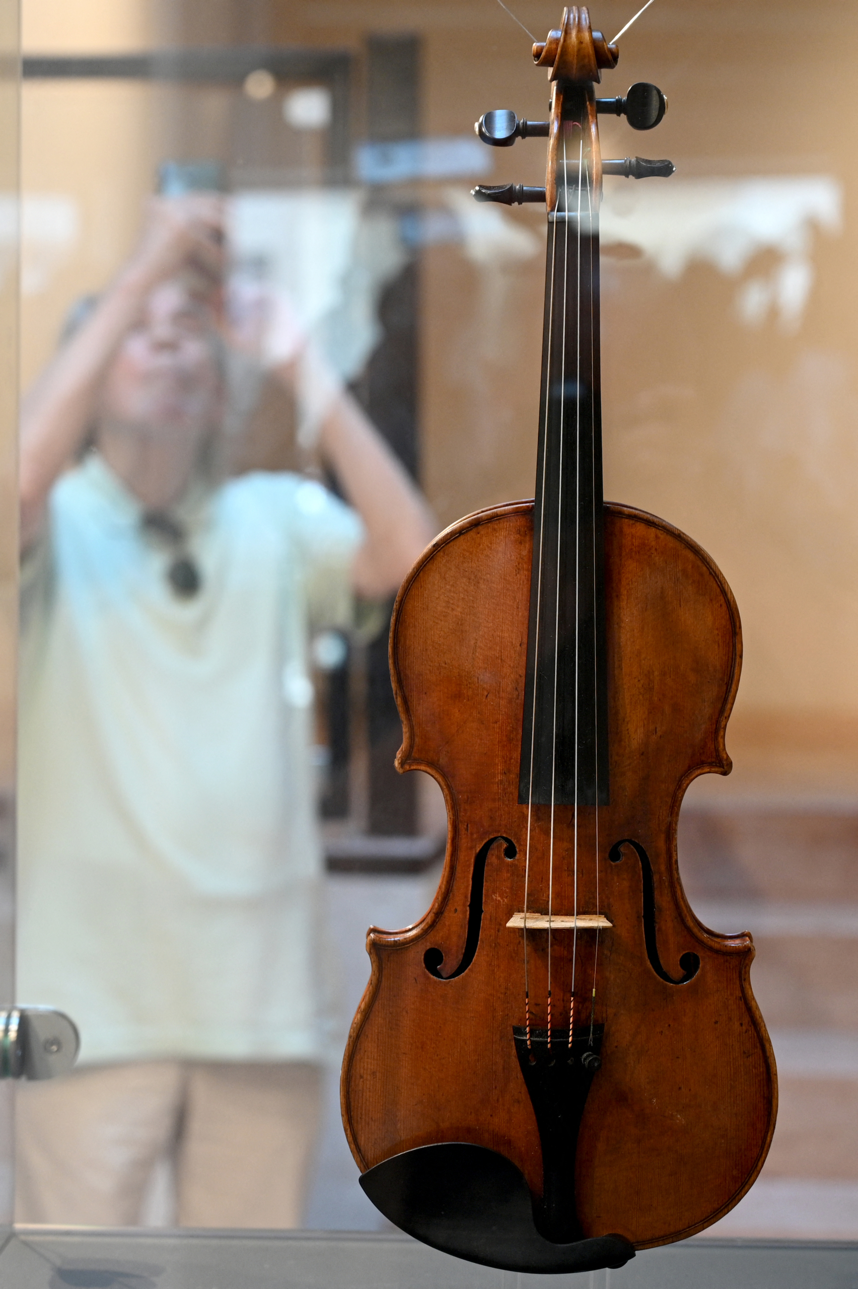 Một du khách đang chụp ảnh cây vĩ cầm do Stradivari chế tác năm 1720 vào hôm 04/07/2023 tại Cremona, Ý, sau khi ngôi nhà của Stradivari mở cửa trở lại. Nhà sản xuất vĩ cầm nổi tiếng Antonio Stradivari đã từng sống và mở xưởng vẽ của mình ở đây vào năm 1667. (Ảnh: Gabriel Bouys/AFP)