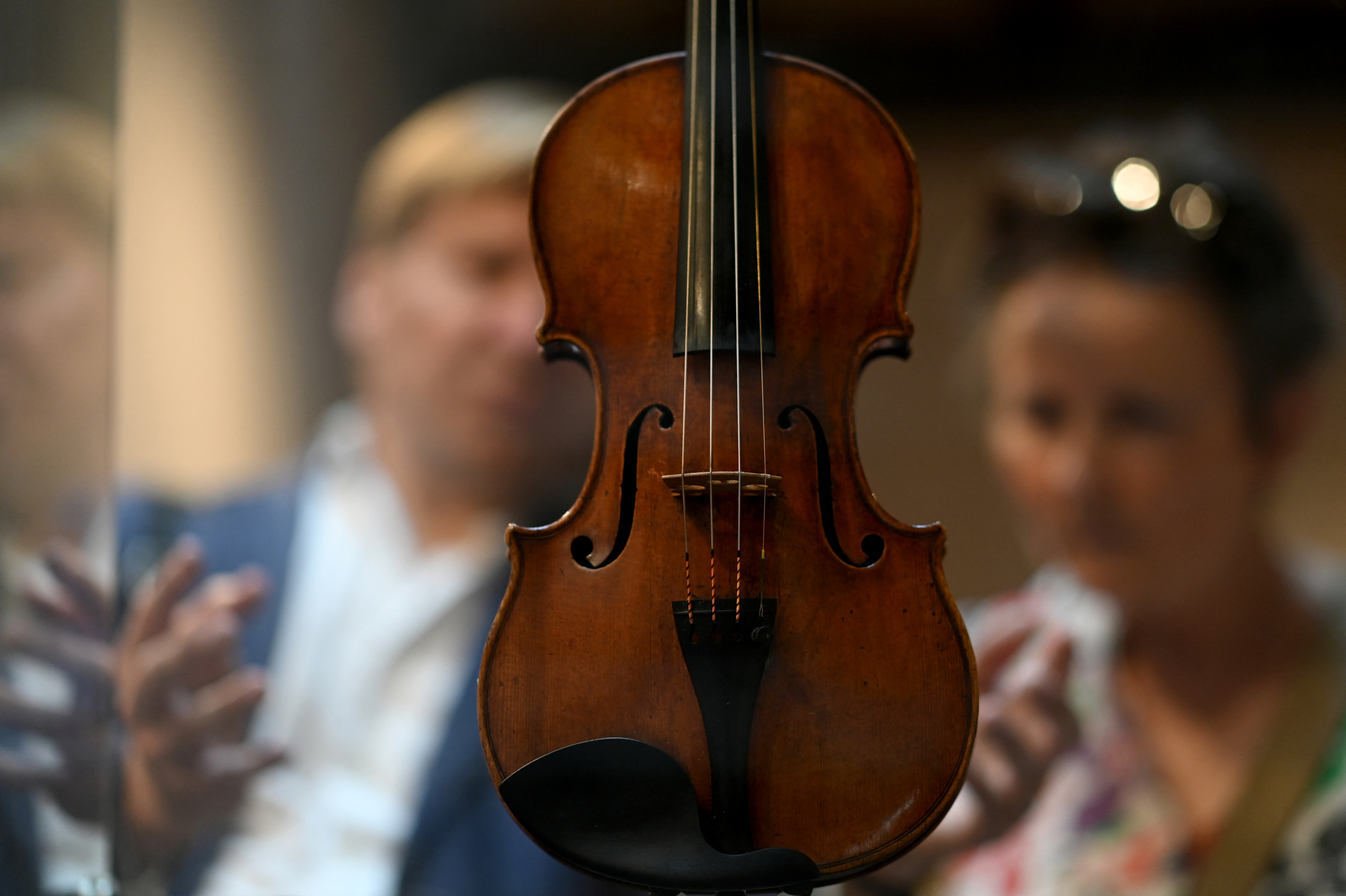 Du khách đang thưởng lãm cây vĩ cầm do nghệ nhân Stradivari chế tác năm 1720 vào hôm 04/07/2023 tại Cremona, Ý, sau khi ngôi nhà của Stradivari mở cửa trở lại. Nhà sản xuất vĩ cầm nổi tiếng Antonio Stradivari đã từng sống và mở xưởng vẽ của mình ở đây vào năm 1667. (Ảnh: Gabriel Bouys/AFP)