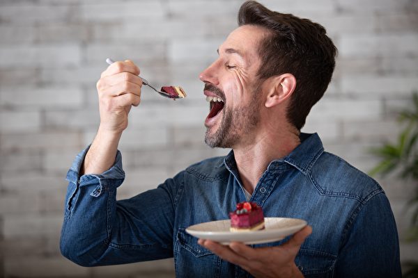 Hình ảnh một người đàn ông đang ăn bánh gato. (Ảnh: Shutterstock)