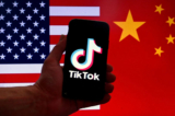 Logo ứng dụng mạng xã hội TikTok hiển thị trên màn hình iPhone trước nền cờ Hoa Kỳ và cờ Trung Quốc ở Hoa Thịnh Đốn, hôm 16/03/2023. (Ảnh: Olivier Douliery/AFP qua Getty Images)