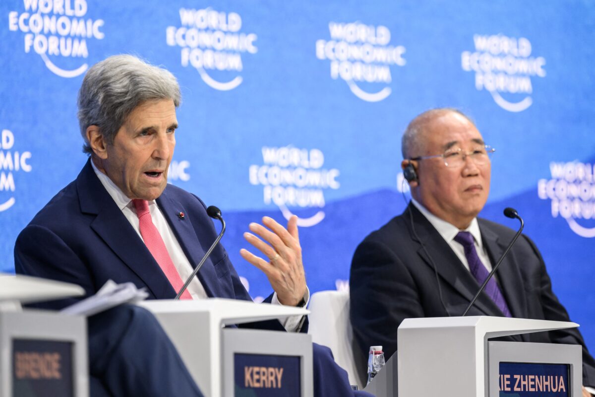 Đặc phái viên về khí hậu của Hoa Kỳ John Kerry (trái) ra hiệu khi nói chuyện bên cạnh đặc phái viên về khí hậu của Trung Quốc Giải Chấn Hoa (phải) trong một phiên họp tại cuộc họp thường niên của Diễn đàn Kinh tế Thế giới ở Davos vào ngày 24/05/2022. (Ảnh: Fabrice Coffrini/AFP qua Getty Images)