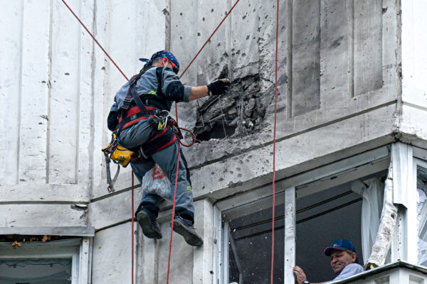 Một chuyên gia kiểm tra mặt tiền bị hư hại của một tòa nhà chung cư nhiều tầng sau một cuộc tấn công bằng phi cơ không người lái được ghi nhận ở Moscow hôm 30/05/2023. (Ảnh: Kirill Kudryavtsev/AFP qua Getty Images)