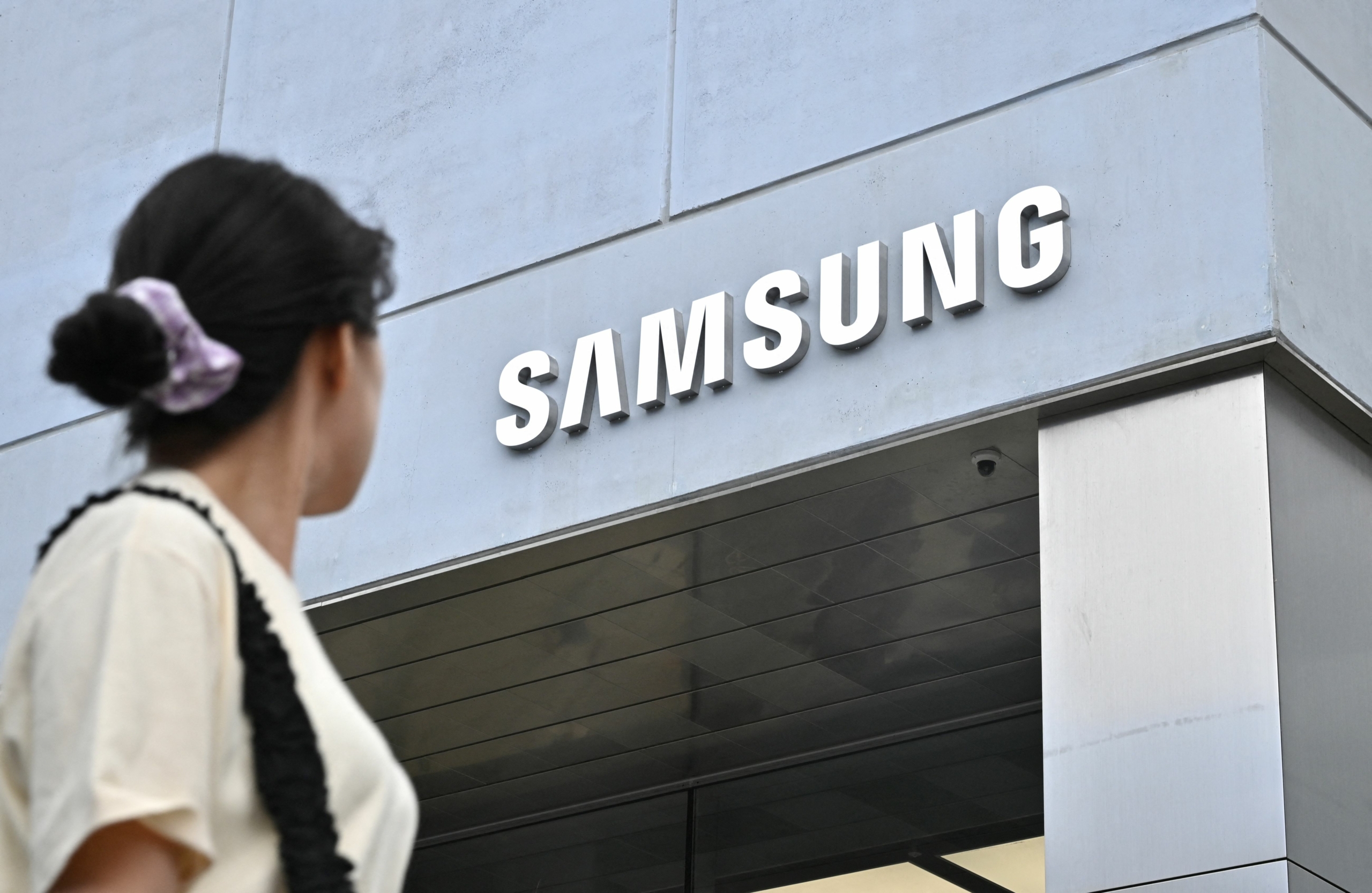 Một người phụ nữ đi ngang qua một cửa hàng flagship (cửa hàng đại diện cho một thương hiệu) mới của Samsung Electronics ở quận Gangnam, Seoul, hôm 28/06/2023. (Ảnh: Jung Yeon-je/AFP qua Getty Images)